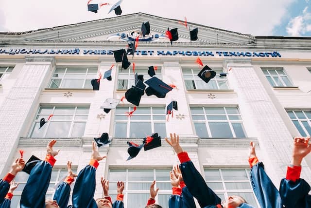 college students throwing their graduation caps up in the air
