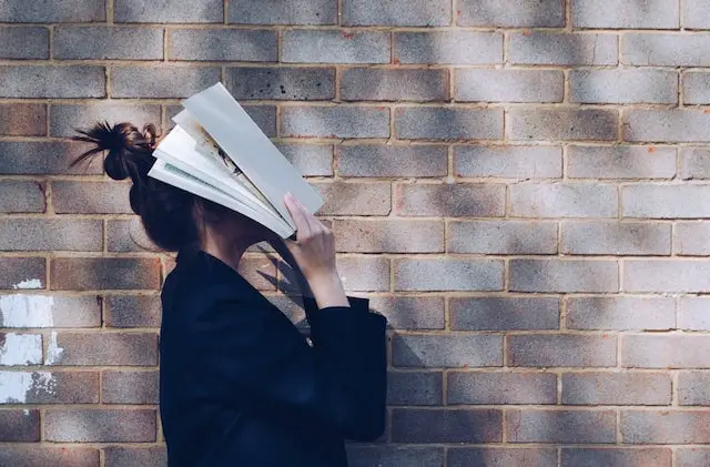 Female covering her face with a book