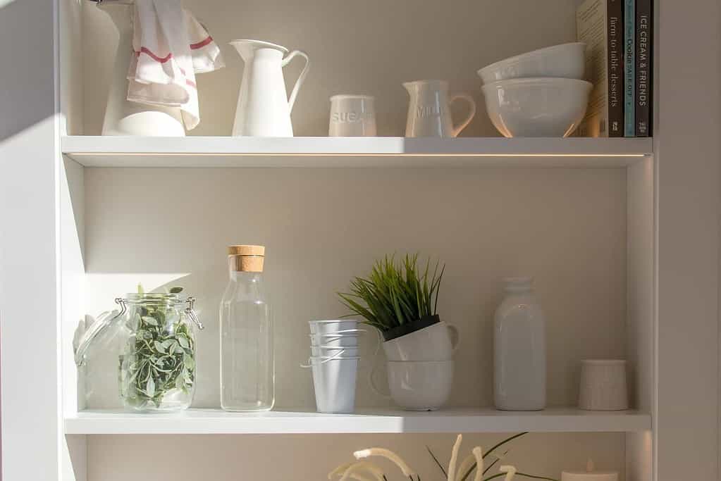 kitchen items like bowls and bottles stored on shelves