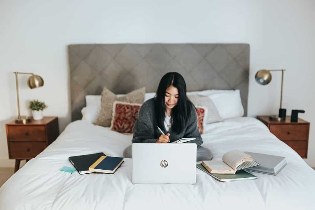 girl studying on her laptop in bed