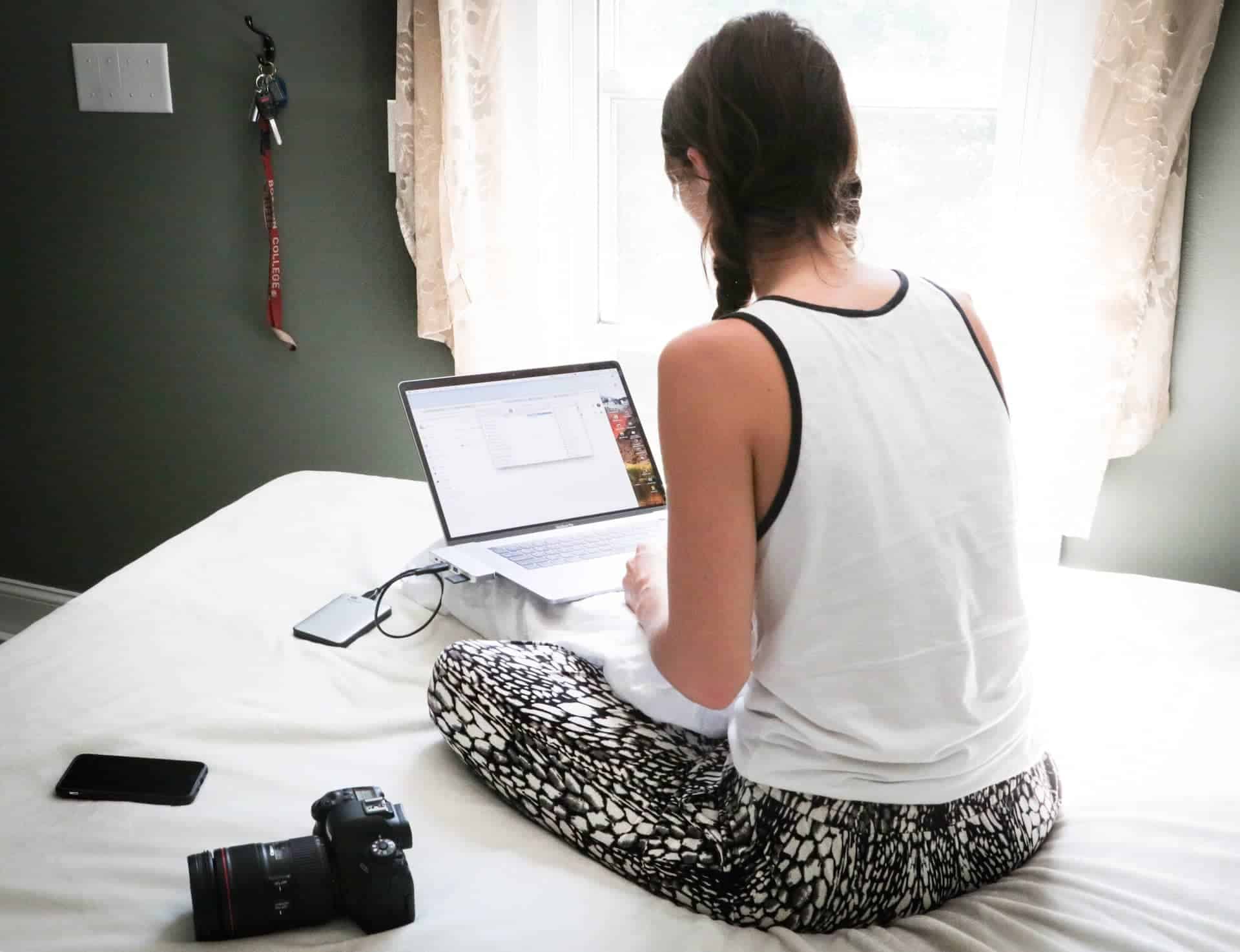 girl using laptop in her bed