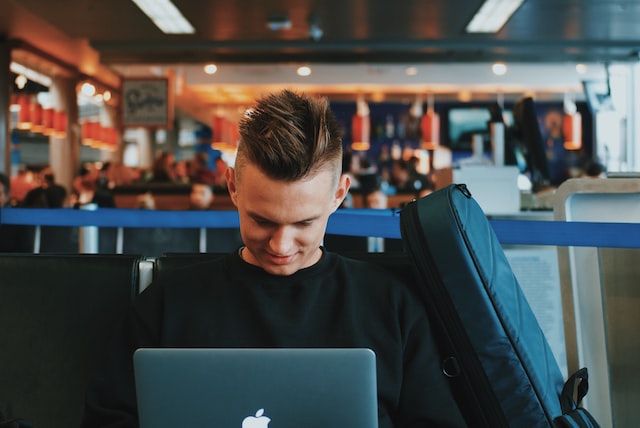 Man on his laptop and sitting inside an airport