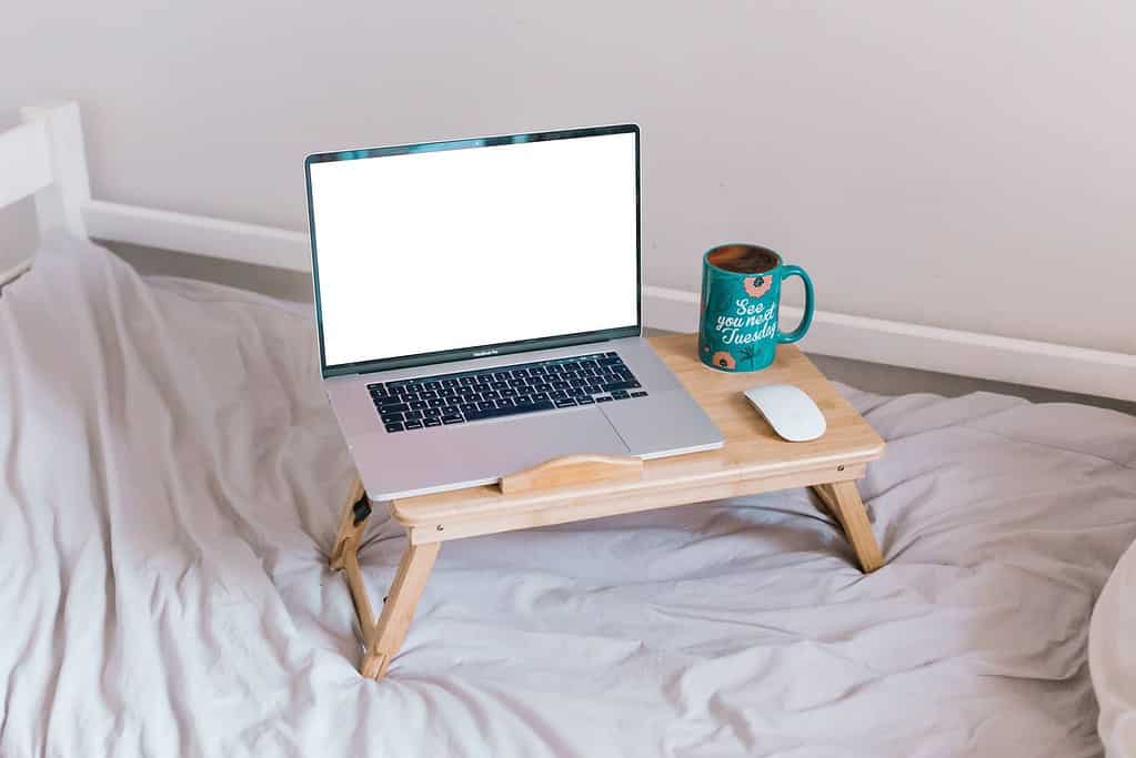 laptop on a laptop stand on a bed