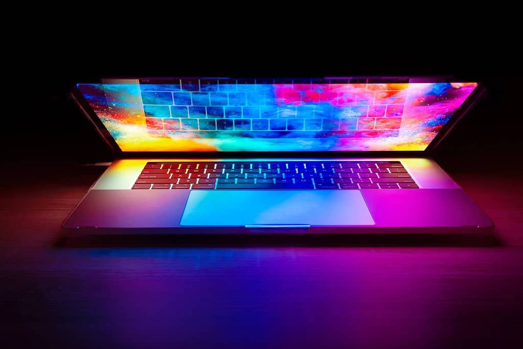 laptop on desk with colourful multicoloured wallpaper