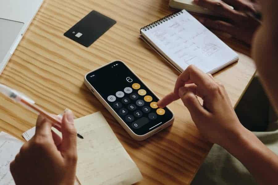 hand typing on the calculator app open in an iphone