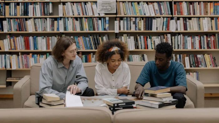3 students sitting on sofa in library and learning about common study mistakes