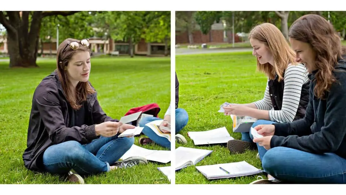 students testing out active learning vs flashcards technique while sitting on the grass outside testing each other