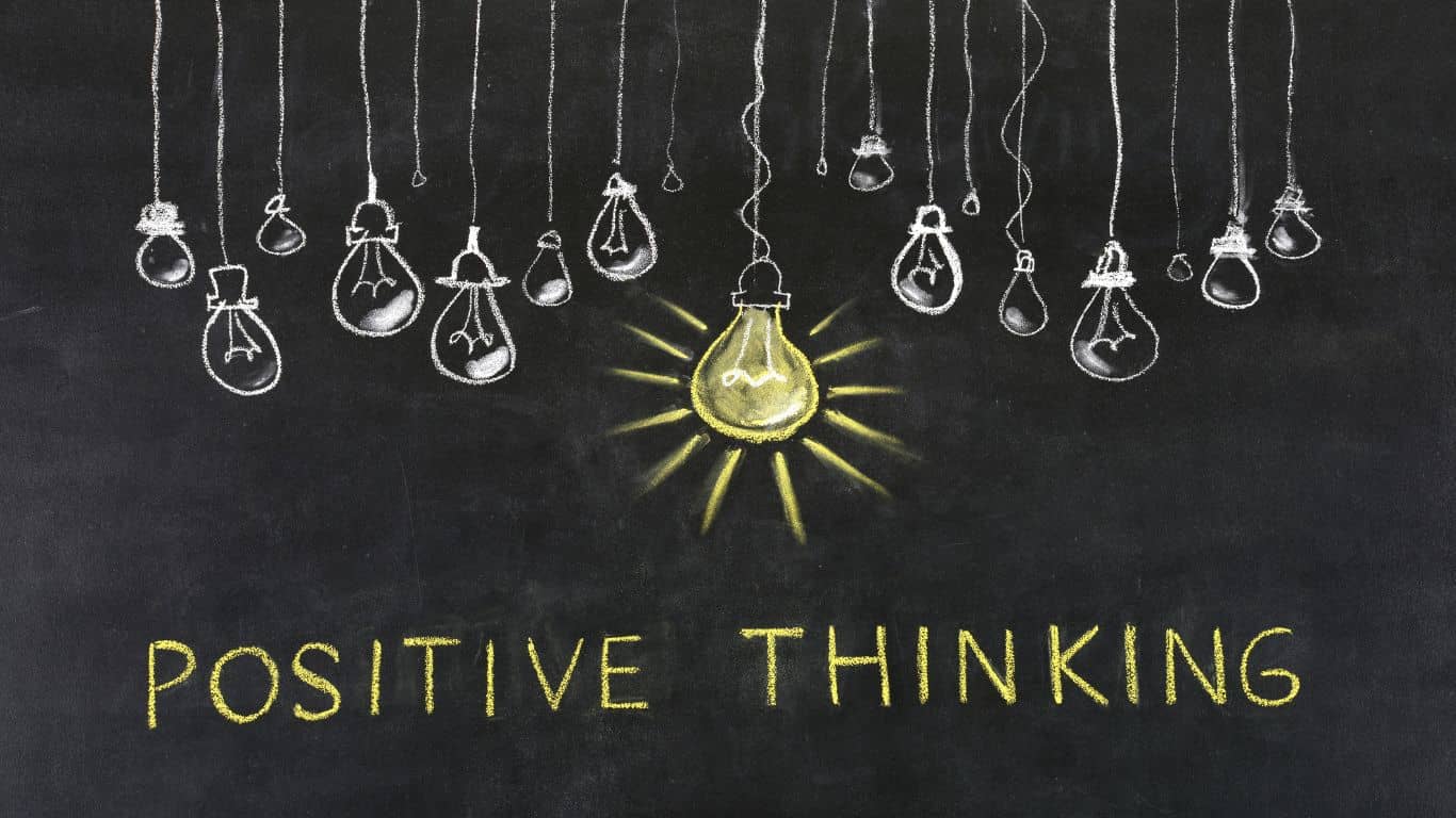 positive thinking written in words on black background with lightbulbs drawings