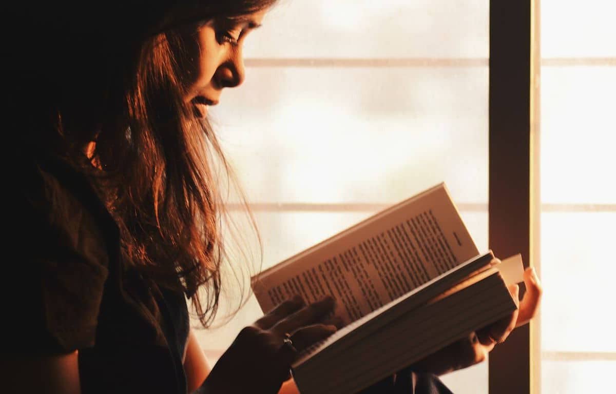 female rereading a open book in her hand
