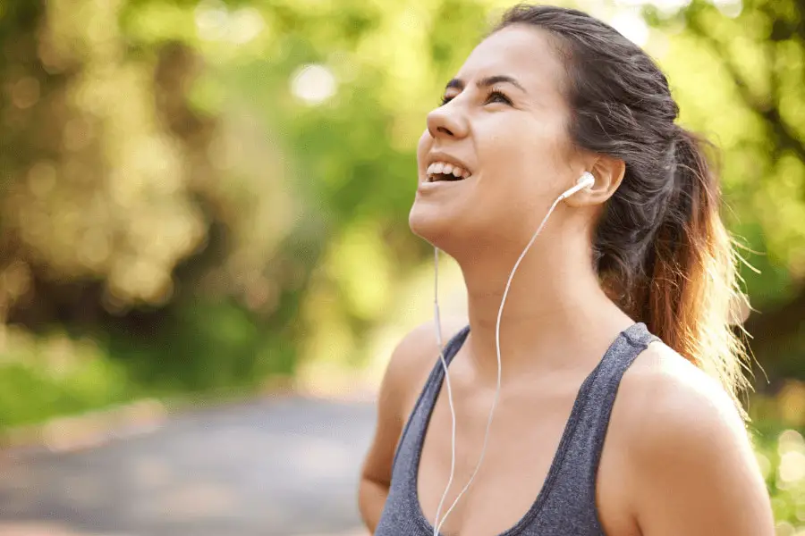 female runner wearing headphone and listening to audio recording of lecture