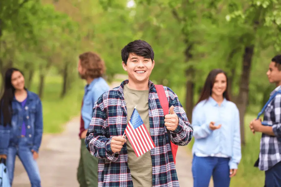 male student holding a USA flag while on campus