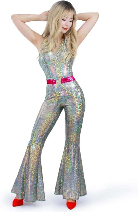 Image of a woman wearing a shiny silver holographic jumpsuit with flared legs, a hot pink sequin belt, and red heels. This dazzling disco-inspired outfit is perfect for **Barbie Halloween Costumes for Adults**, channeling a glamorous 70s disco Barbie style ideal for Halloween parties or themed costume events.