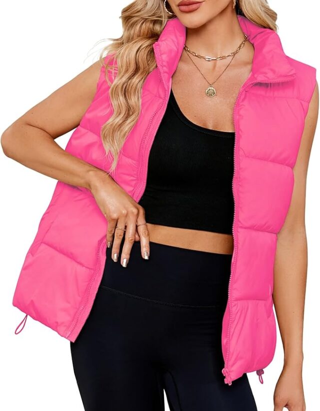 Image of a woman wearing a bright pink puffer vest over a black crop top and black leggings, accessorized with layered gold necklaces. This trendy and casual look is ideal for **Barbie Halloween Costumes for Adults**, giving off a modern, sporty Barbie vibe perfect for a stylish and comfortable Halloween outfit.